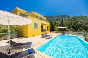 A yellow villa with a swimming pool, outdoor seating, and a view of the mountains. - Villa Inna - Three Bedroom Villa, Sleeps 6 (Lefkada)