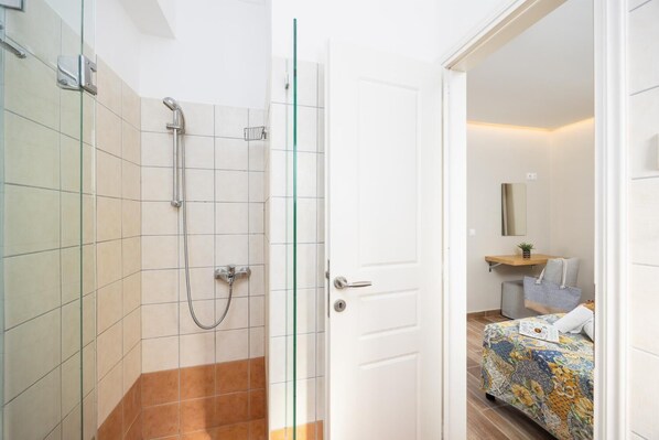 A bathroom with a shower, a toilet, and a sink. - Villa Eleni Agios Stephanos (Άγιος Στέφανος)