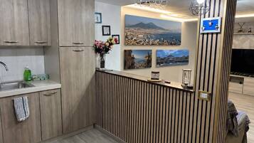 Eine moderne Küche mit Holzschränken, einer integrierten Kochinsel, einem Spülbecken und einer dekorativen Vase.