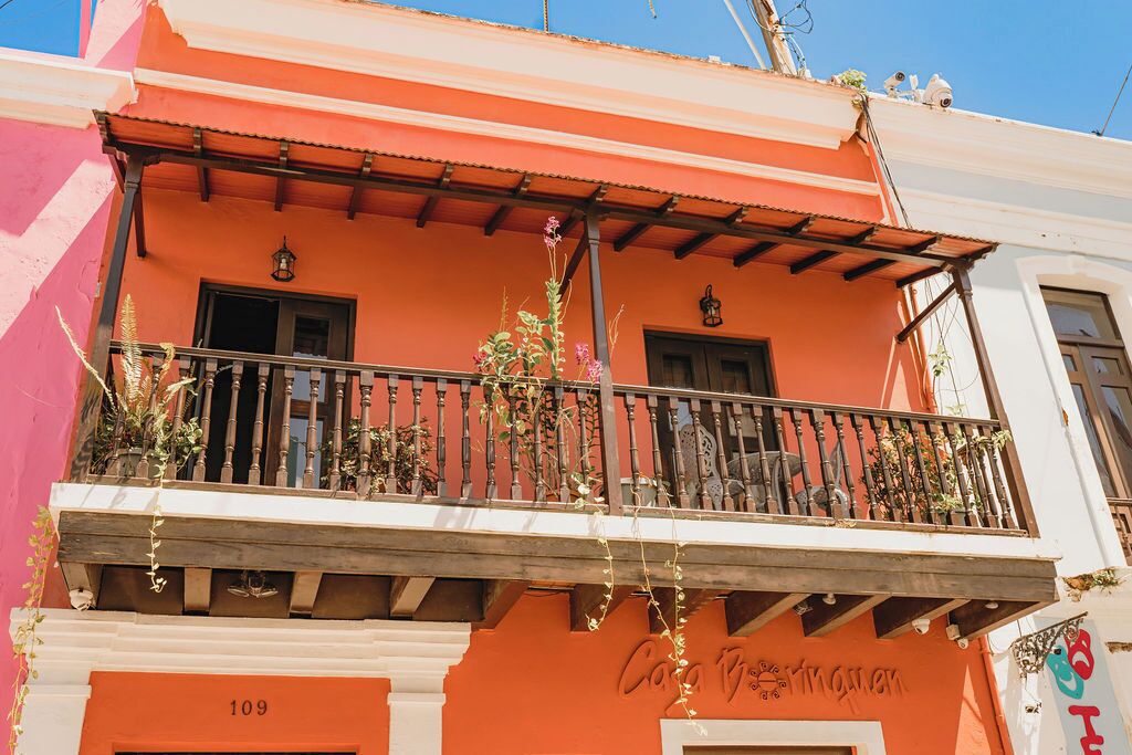 A building with a balcony, a door labeled "109", and a sign with the text "Casa de la Memoria".