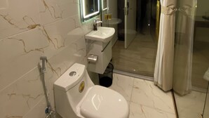 A modern bathroom with a toilet, sink, and glass shower enclosure. - Eighth Wonders Hotel (Wadi Musa)