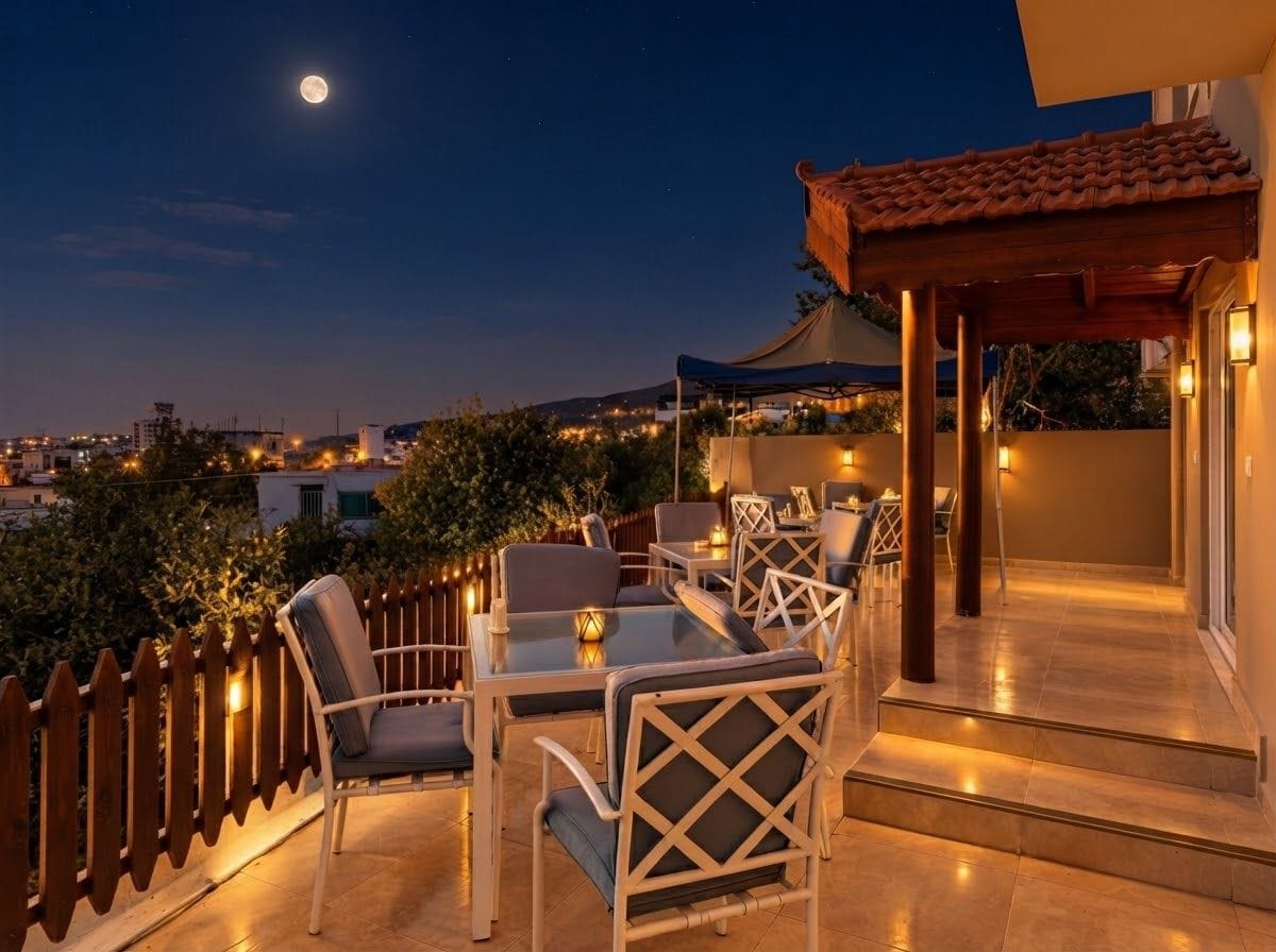 Un patio al aire libre con mesas y sillas, una pérgola de madera y vistas de la ciudad de noche.