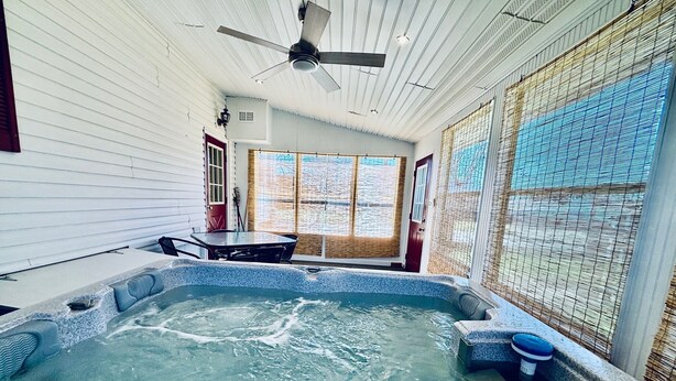 Un jacuzzi con panel de control, un ventilador de techo y una ventana con vistas al exterior.
