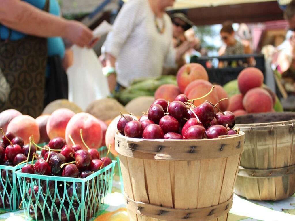 Ein Obststand mit Körben voller Kirschen und Pfirsichen.