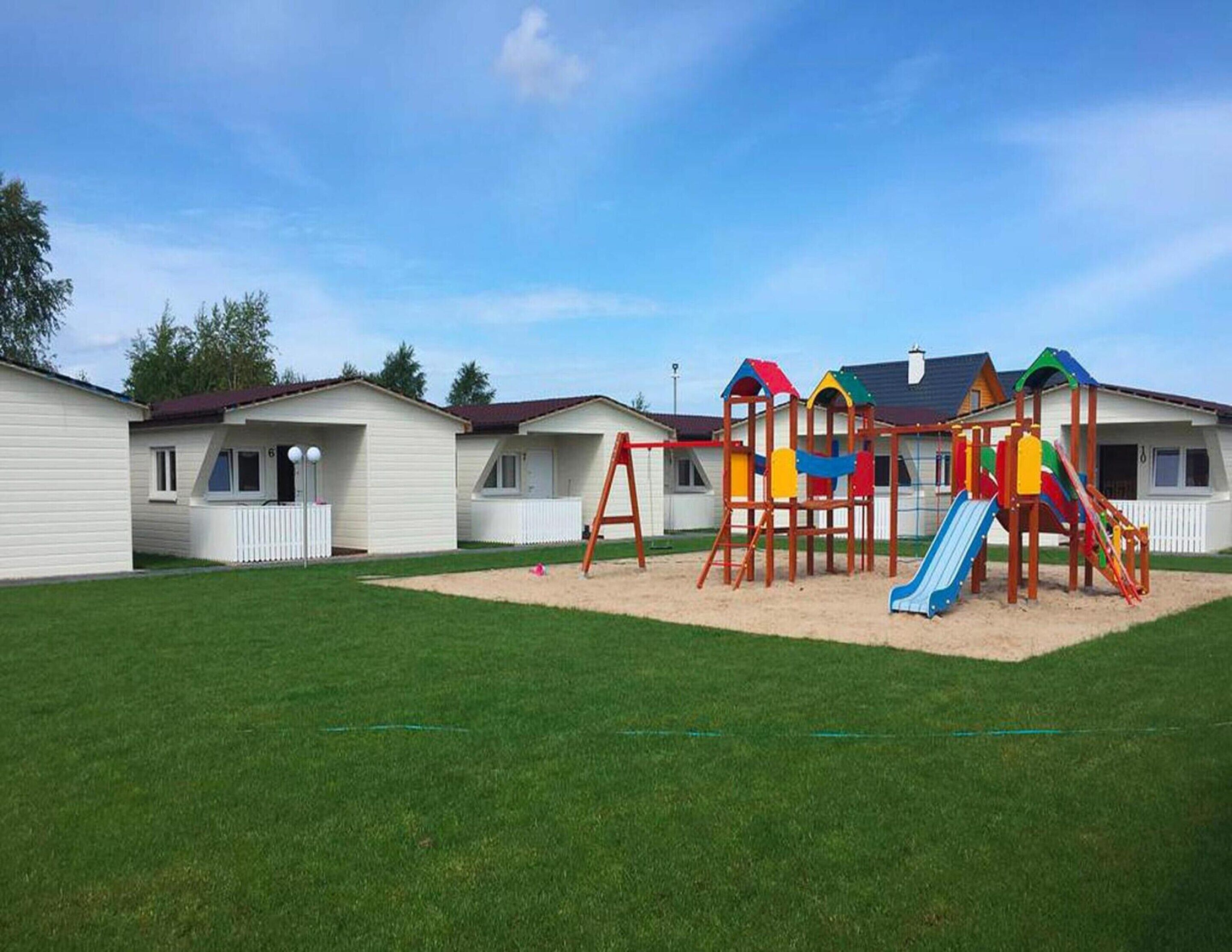 A row of mobile homes with a playground in the yard.