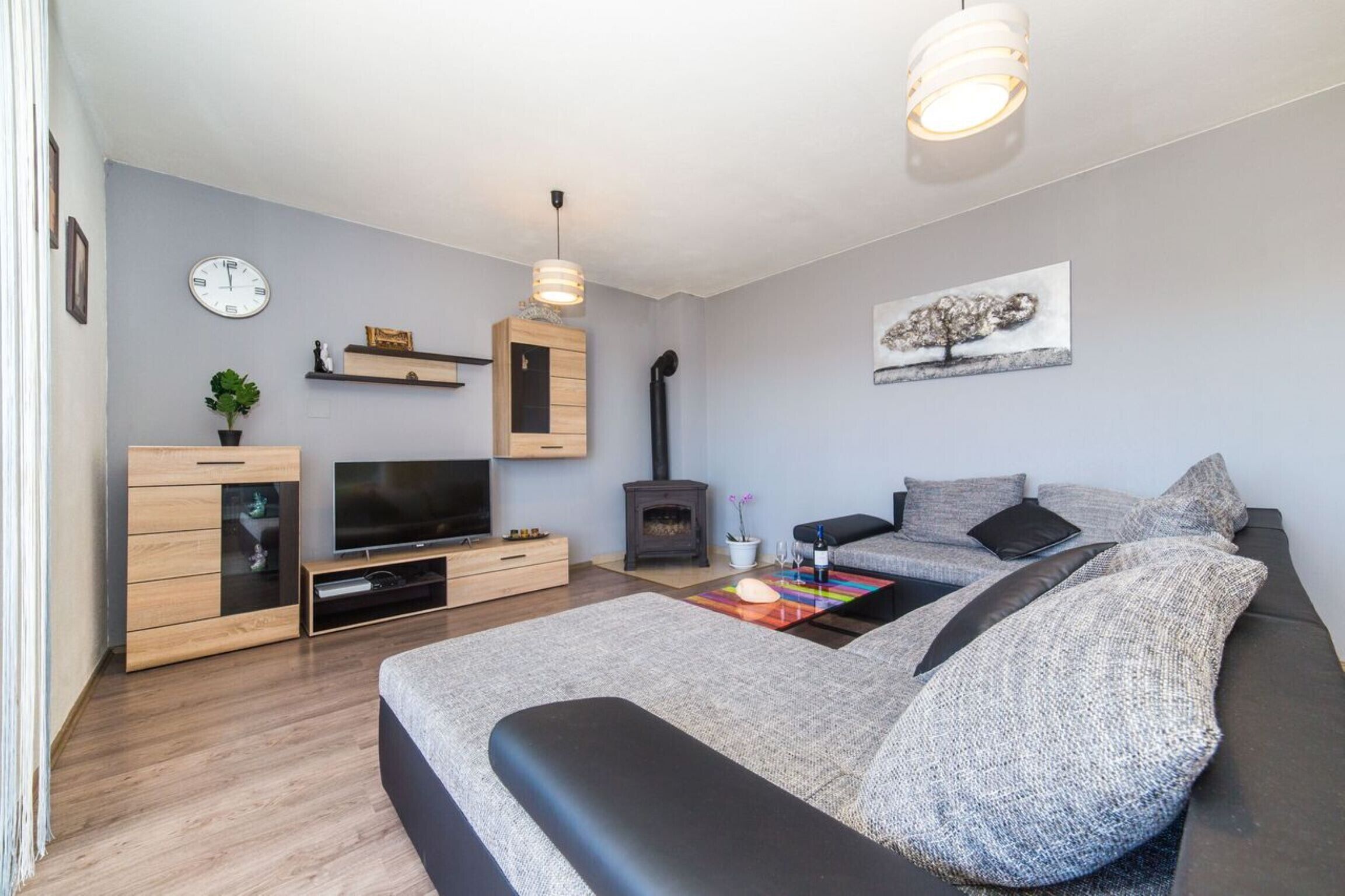 Un salon moderne avec un canapé, un téléviseur, un meuble en bois et une cheminée.