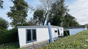 Una casa móvil blanca con un pequeño porche y una ventana.