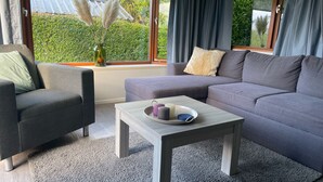Una sala de estar moderna con un sofá gris, un sillón a juego y una mesita de centro de madera.