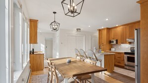 Une cuisine moderne avec des meubles en bois, un îlot central et des appareils électroménagers en acier inoxydable.