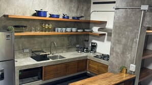 A modern kitchen with a central island, wooden cabinets, and a stainless steel sink. - Cozy chic studio near the beach! (Puerto Vallarta)