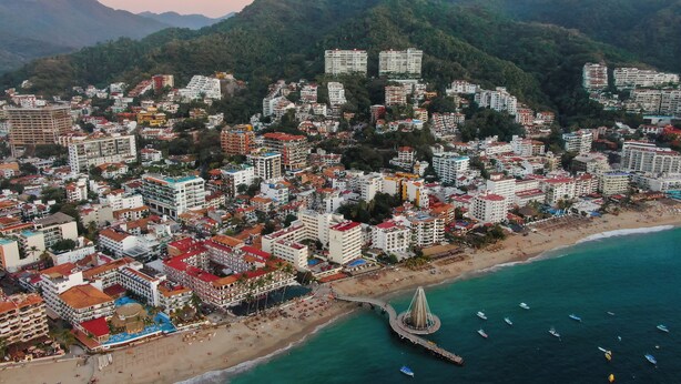 An aerial view of a coastal city with dense urban development, a beach, and a prominent tower structure. - Cozy chic studio near the beach! (Puerto Vallarta)