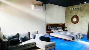 A modern bedroom with a sofa, a bed, and a wall-mounted air conditioner. - Cozy chic studio near the beach! (Puerto Vallarta)