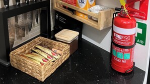 Eine Küche mit Feuerlöscher, Kaffeemaschine und einem Brotkorb.