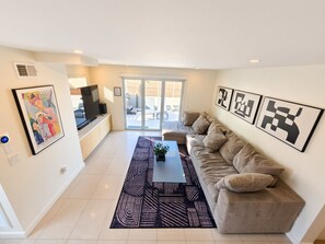 A modern living room with a sofa, a coffee table, and artwork on the walls.