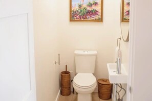 A small, clean bathroom with a toilet, sink, and two wooden baskets. - Hillside Oasis with Jacuzzi, Ocean Views, BBQ, Treetop Master, EV Charger (San Diego)