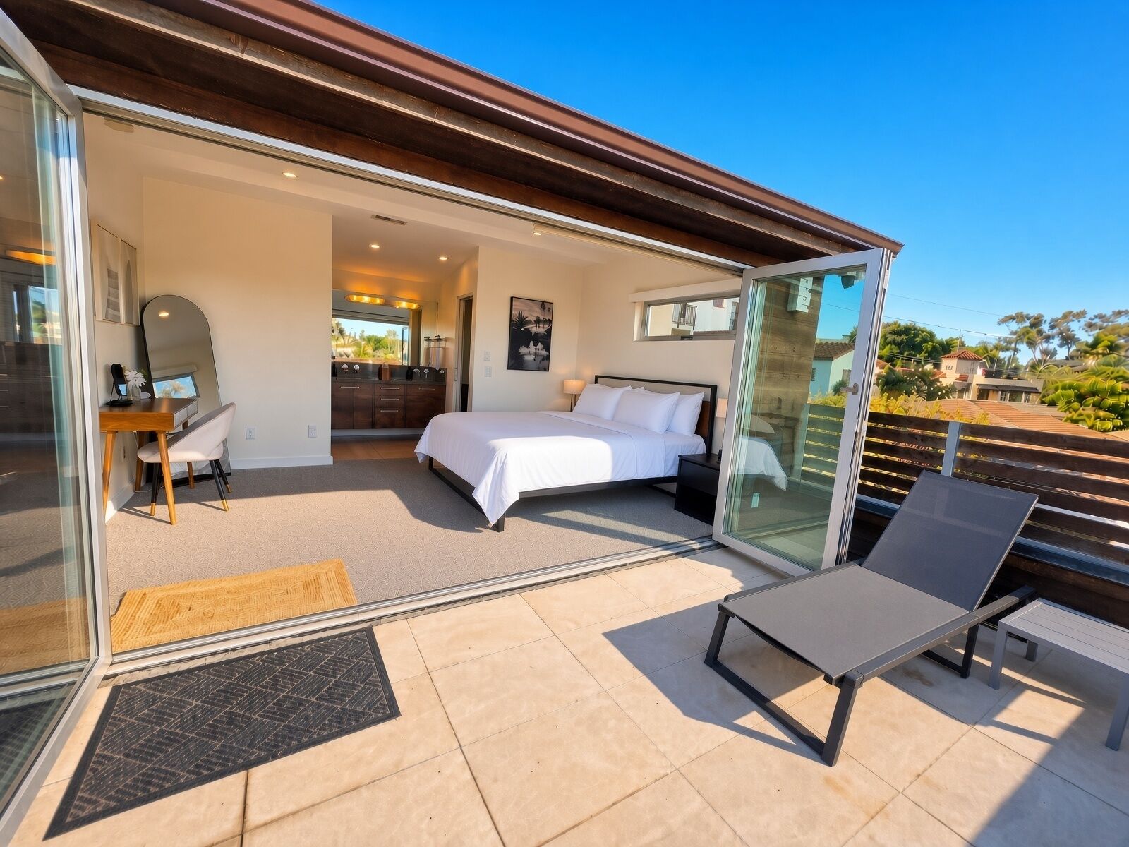 Een moderne slaapkamer met een groot bed, een bureau en een balkon met glazen wanden.