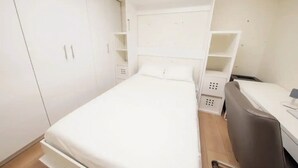 Une chambre à coucher avec un lit, un bureau et une chaise.
