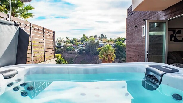 Un bain à remous offrant une vue sur un quartier résidentiel et un bâtiment moderne.