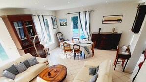 A spacious living room with a sofa set, a coffee table, and a dining area with a table and chairs.