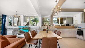 A modern kitchen with a wooden table, brown leather chairs, and a stone wall. - Gorgeous apartment in Jezera (Jezera)
