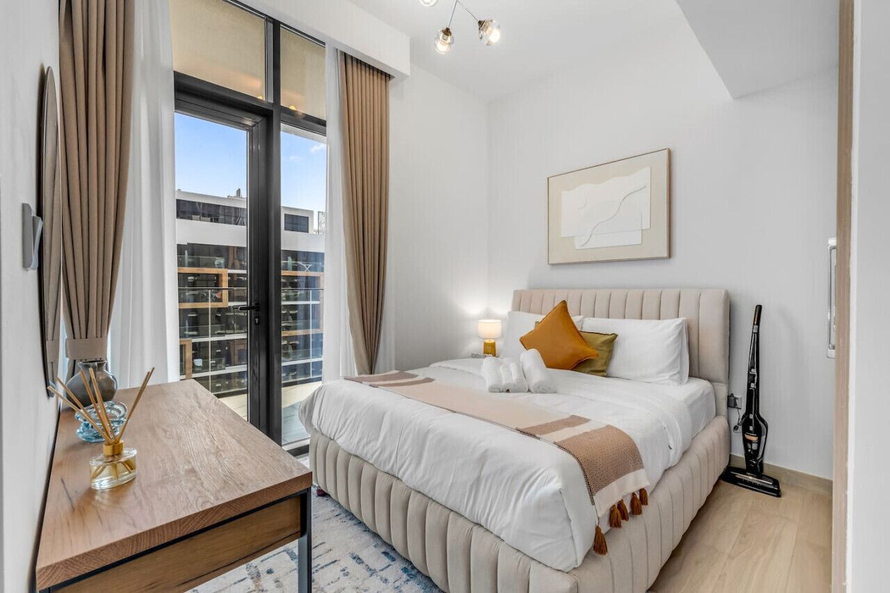 Een moderne hotelkamer met een groot bed, een nachtkastje, een raam met gordijnen en uitzicht op de stad.