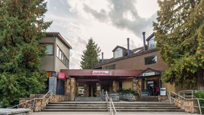 A building with a Village Centre sign, stone steps, and a bike rack outside.