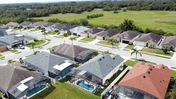 A residential area with houses, a swimming pool, and a green field. - Walk to Silver Spurs Rodeo and Heritage Park (Kissimmee)