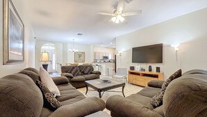 A spacious living room with a large sofa set, a coffee table, and a flat-screen TV mounted on the wall. - Walk to Silver Spurs Rodeo and Heritage Park (Kissimmee)