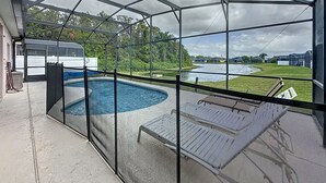 A covered outdoor swimming pool with a view of a river and greenery. - Walk to Silver Spurs Rodeo and Heritage Park (Kissimmee)