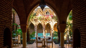 An indoor courtyard with a pool, surrounded by brick arches and palm trees. - Charming  two-bedroom apartment in the centre of Marrakesh Gueliz (Marrakech)