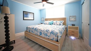 A bedroom with a bed, a nightstand, a dresser, a ceiling fan, and a framed picture on the wall. - Casa Playa #501 - One Bedroom Beach Front - Sand Dollar (Fort Myers Beach)