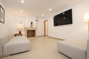 A modern living room with a fireplace, a flat-screen TV, and two sofas. - Villa Alegre (Pollensa / Pollença)