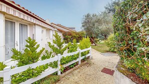A pathway leading to a row of white buildings with a red-tiled roof. - 1 bedroom awesome home in Vaux-sur-Mer (Vaux-sur-Mer)