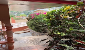 Enjoy a tranquil outdoor space with a neighborhood view, featuring a geometric-patterned floor and lush greenery.
