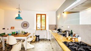 A modern kitchen with a wooden countertop, gas stove, and a window with a view of greenery. - 3 bedroom pet friendly home in Castelreng (Castelreng)