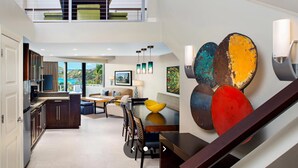 Ein modernes Interieur mit Treppe, Essbereich und Küche.