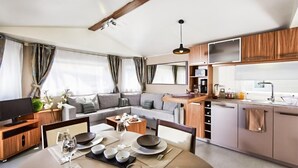 Ein modernes Wohnmobil-Interieur mit Essbereich, Küche und Wohnraum.