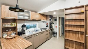Eine moderne Küche mit Holzausstattung, einem Edelstahlspülbecken und einem Fenster.