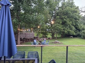 A patio area with outdoor seating, string lights, and a wooden fence.