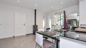 A modern kitchen with a central island, white cabinetry, and a large window with curtains. - Amazing apartment in Saint-Jeannet with WiFi (Saint-Jeannet)