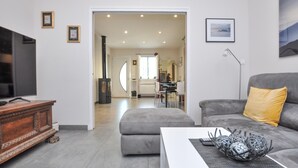 A modern living room with a grey sofa, a wooden cabinet, and a television. - Amazing apartment in Saint-Jeannet with WiFi (Saint-Jeannet)