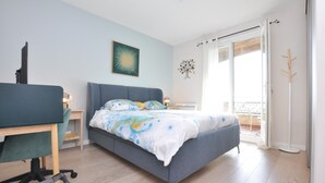 A bedroom with a bed, a desk, and a chair. There is a window with a view of the outside. - Amazing apartment in Saint-Jeannet with WiFi (Saint-Jeannet)