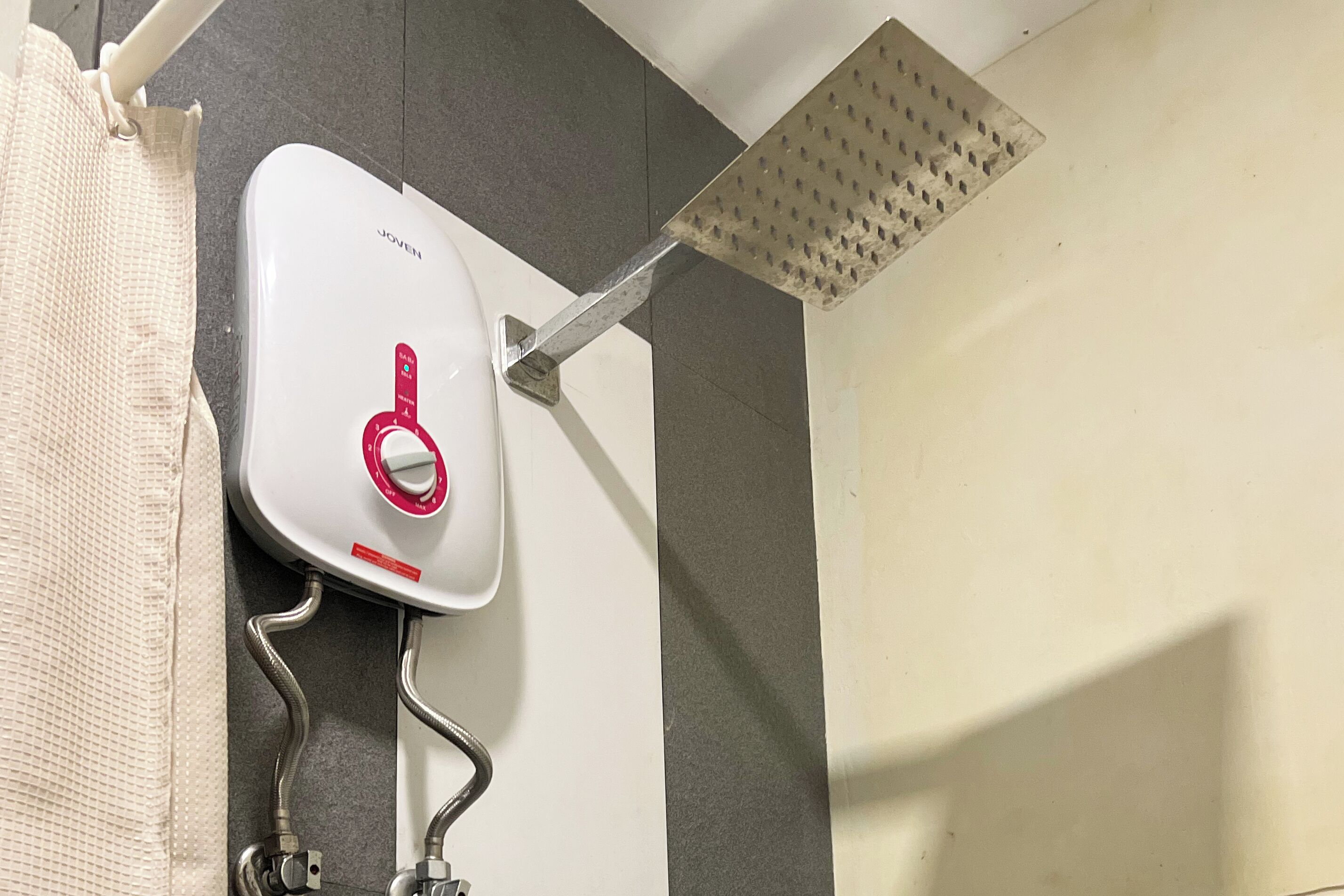 A shower with a handheld showerhead and a wall-mounted rain showerhead.