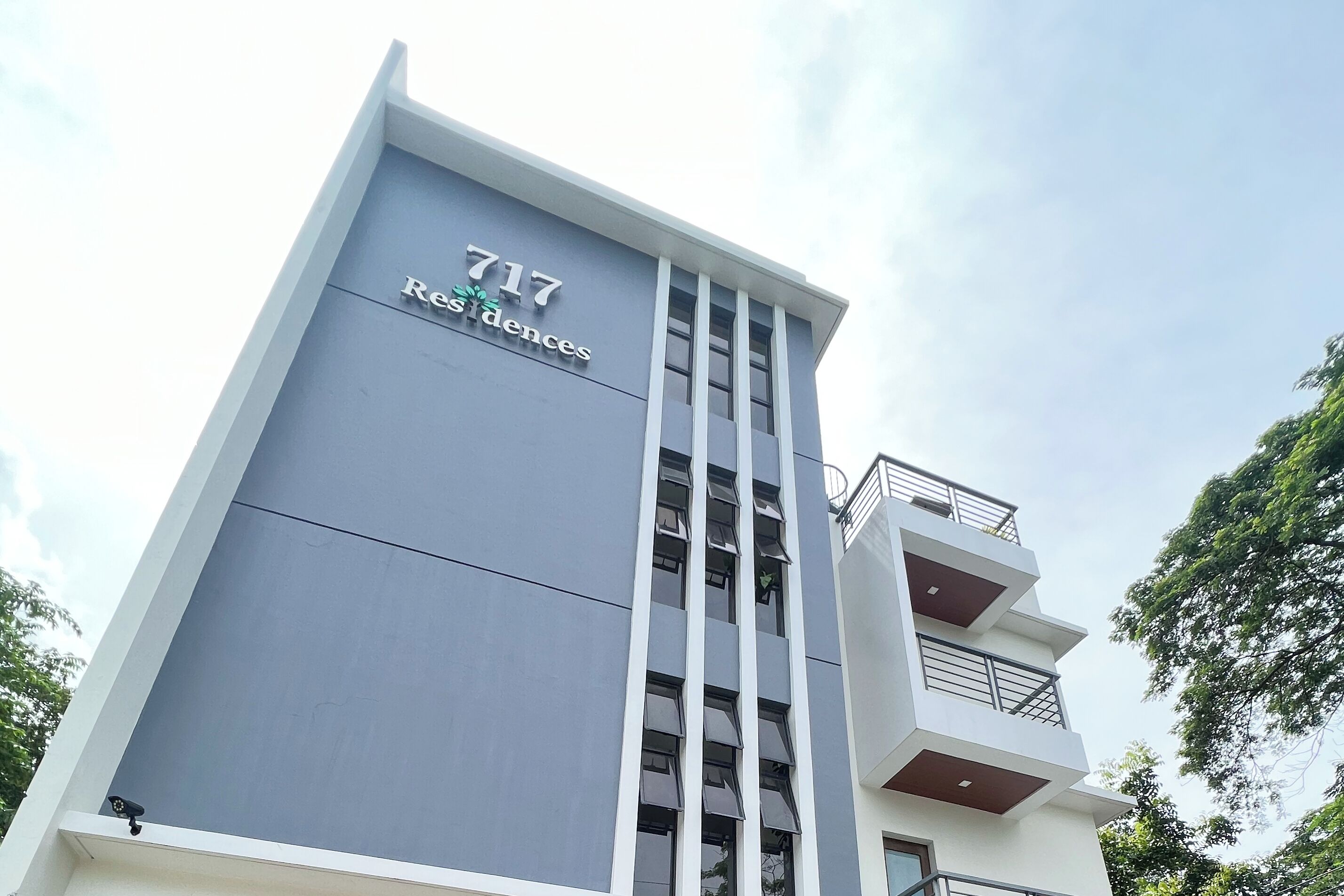 A modern building with the number 717 and the name 'Res d'ences' on the facade.