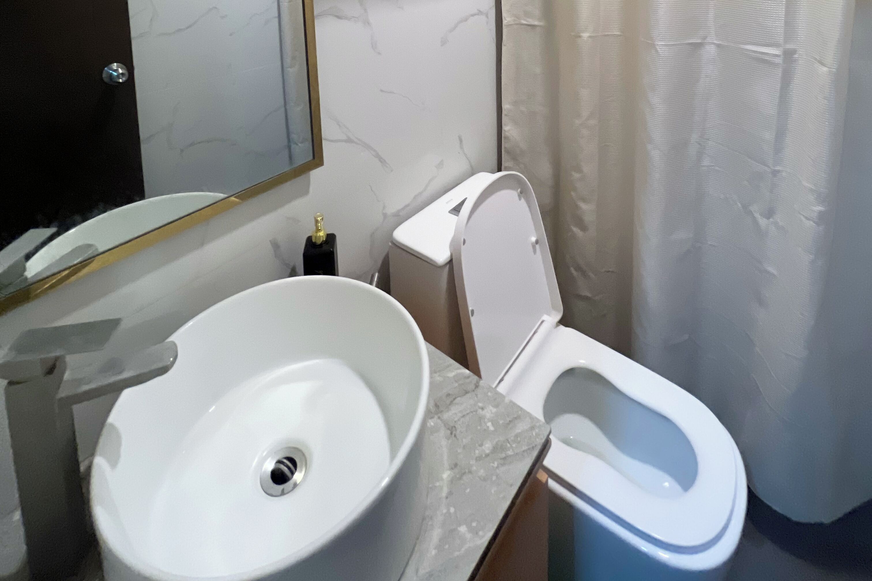 Ein Badezimmer mit weißem Waschbecken, Toilette und Wänden aus Marmorplatten.