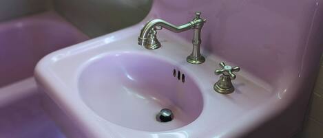 Un lavabo de salle de bain avec un robinet et un distributeur de savon.