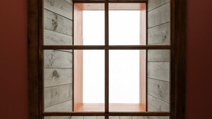 A square window with a wooden frame and a view of wooden walls. - The Well Hotel & Taproom  (Trinidad)