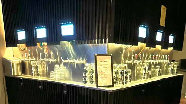 A bar area with a selection of drinks and a charcuterie board in the foreground. - The Well Hotel & Taproom  (Trinidad)