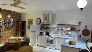 A modern kitchen with white appliances, a wooden dining table, and a bar area.