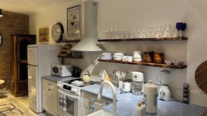 A modern kitchen with a refrigerator, stove, oven, sink, and various appliances like a coffee maker and blender.
